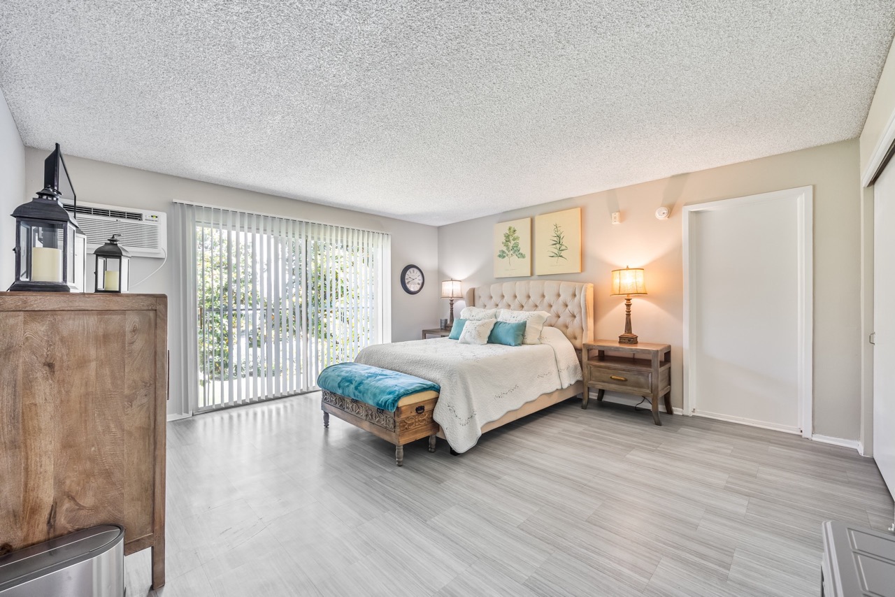 A bedroom with a large bed, a television, and a chair.