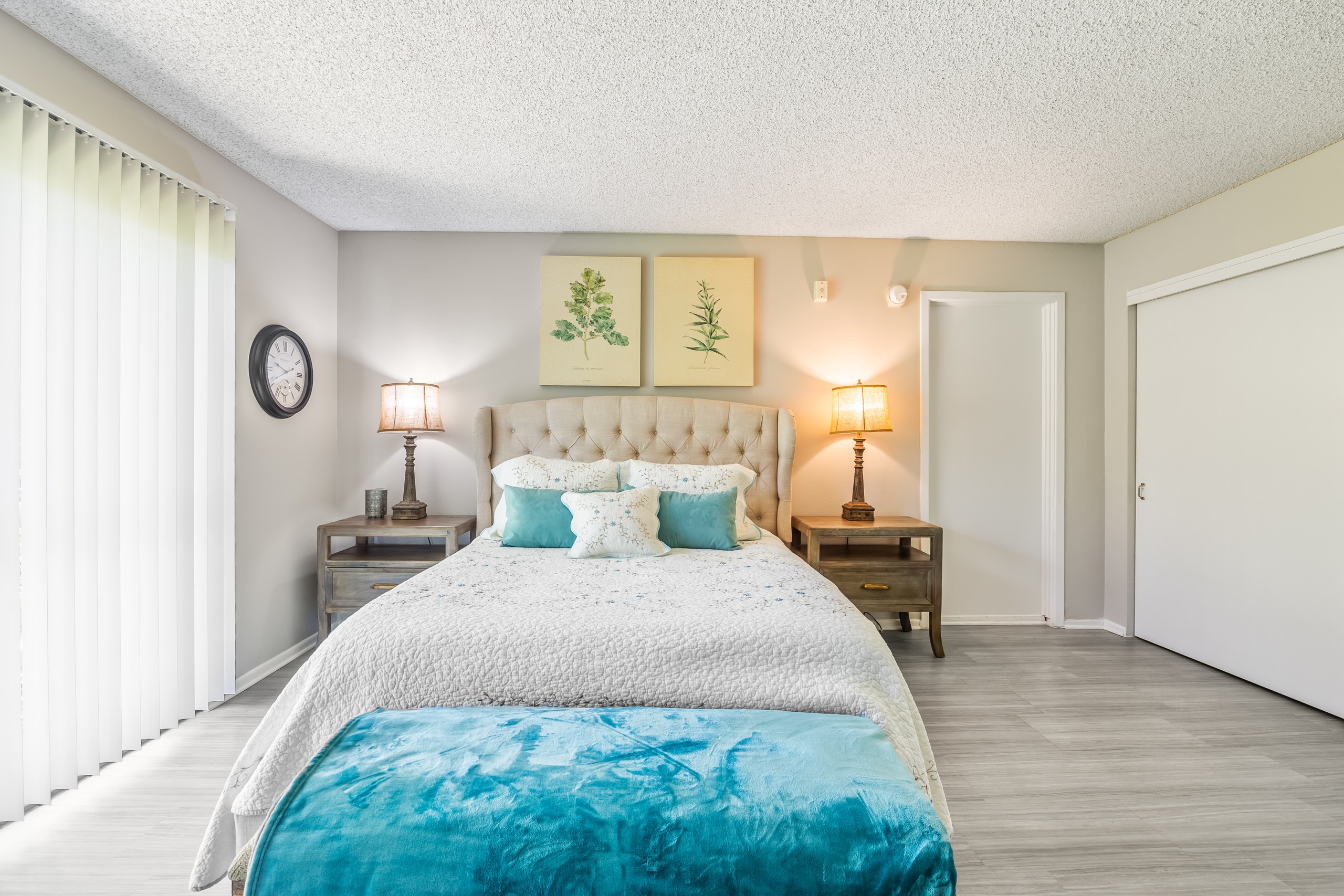 A bedroom with a large bed and a white headboard.