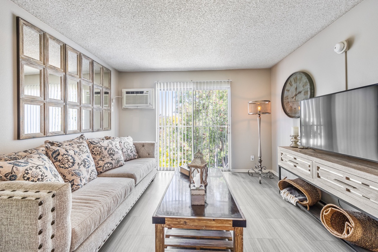 A living room with a couch, a coffee table, and a television.