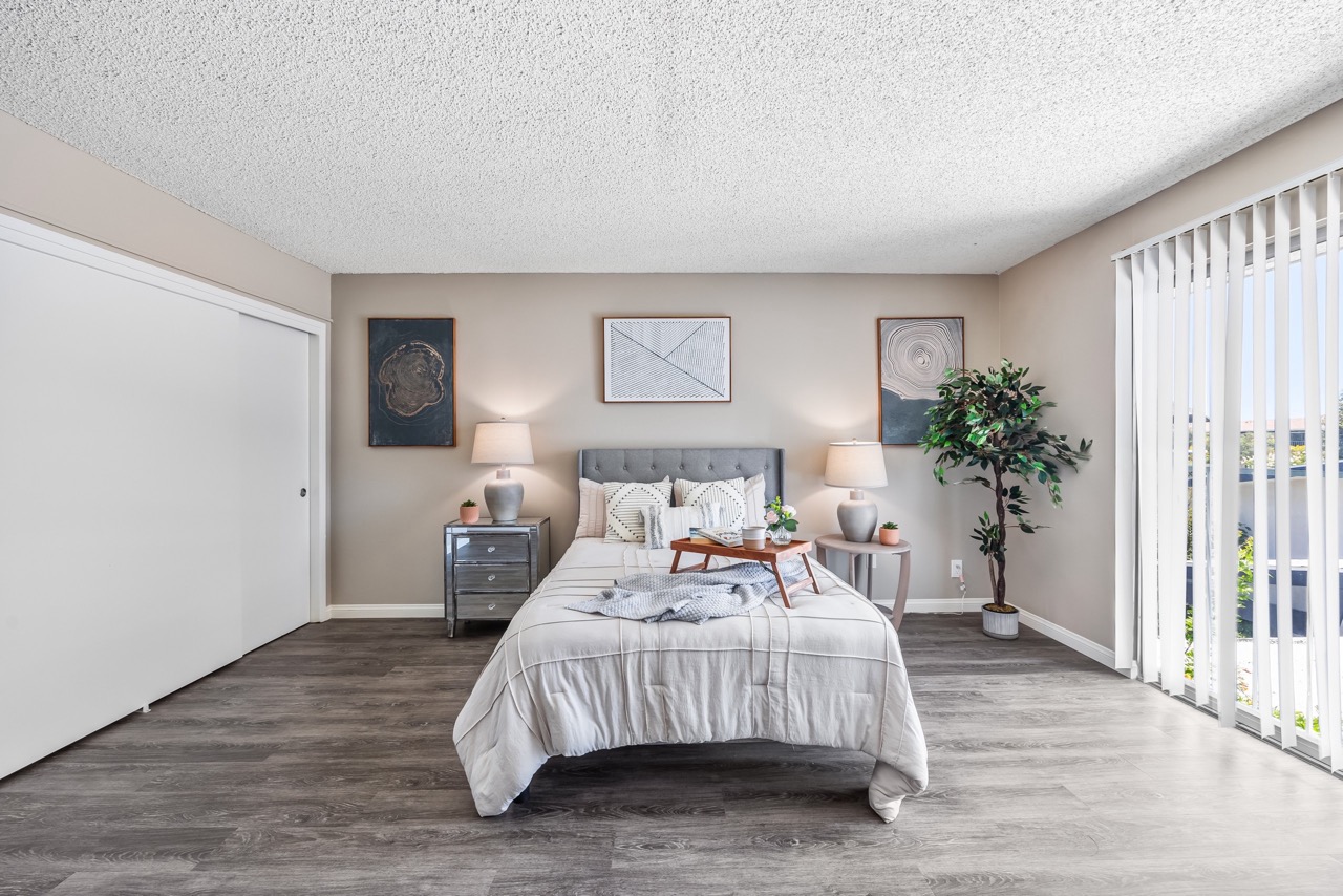 A bedroom with a large bed, a television, and a chair.