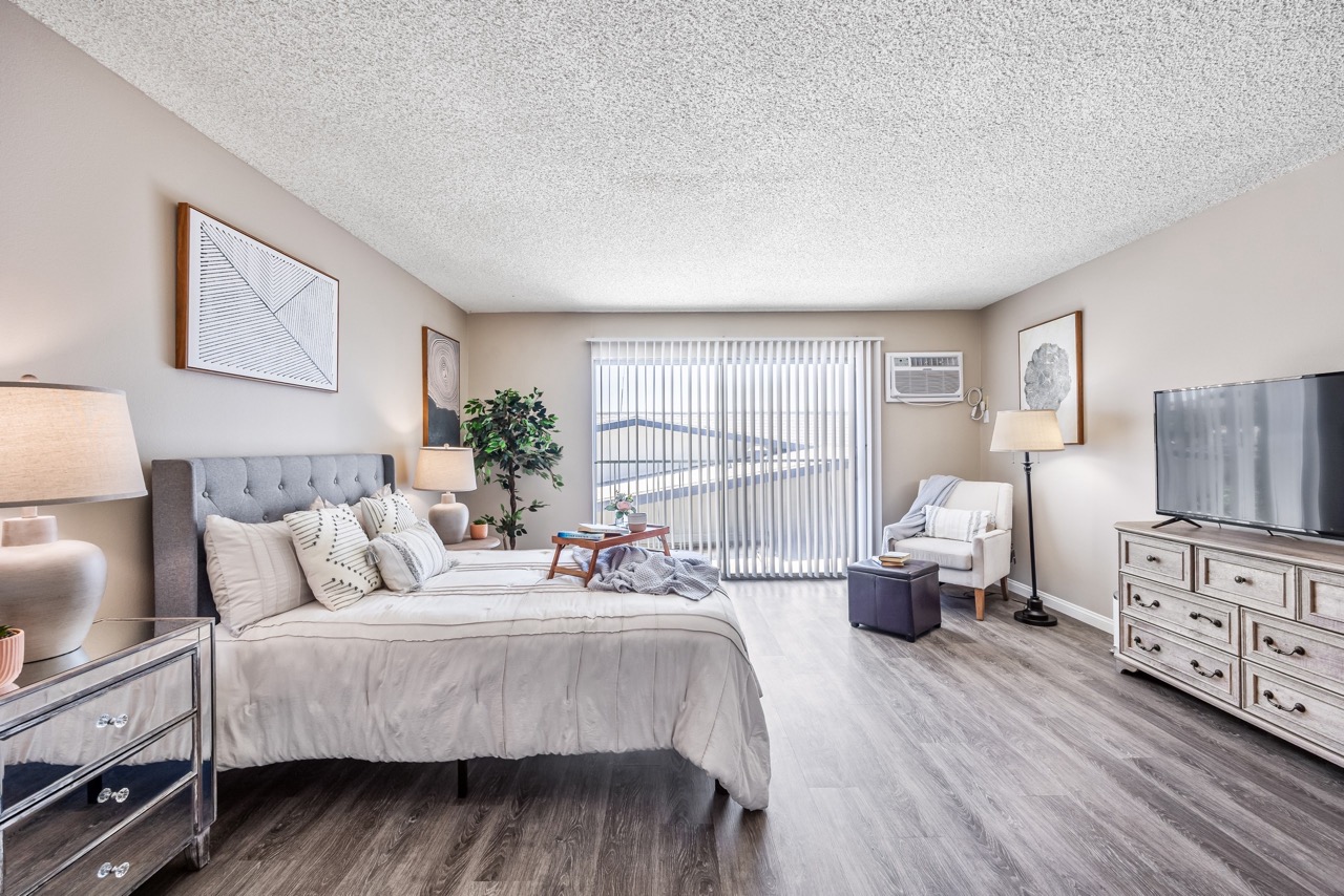 A bedroom with a large bed, a television, and a chair.